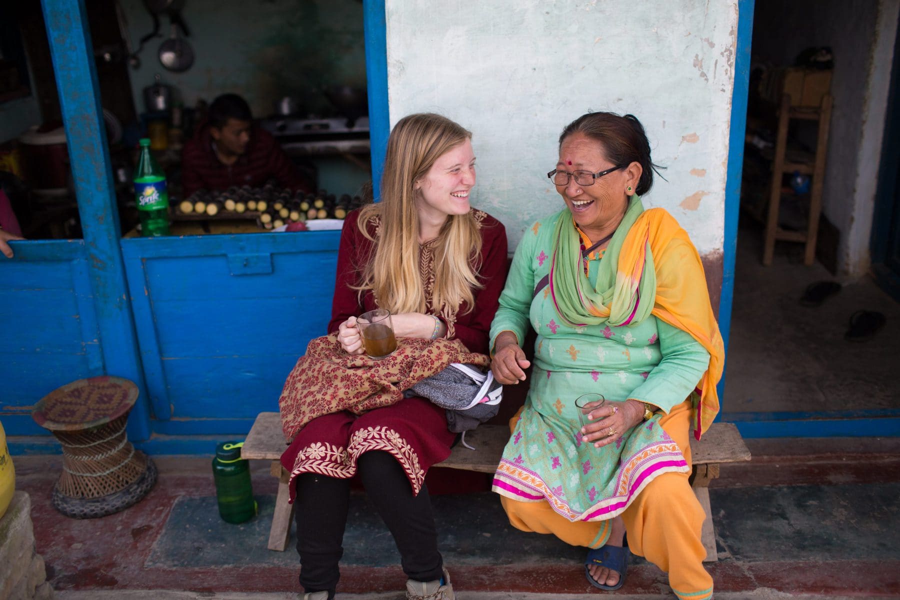 Missionary and her local friend dressed up in traditional clothes, having a cup of tea Missionary and her local friend dressed up in traditional clothes, having a cup of tea
