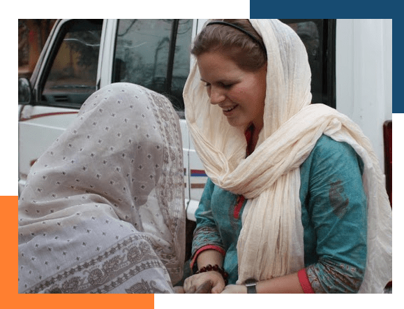 Missionary in a headscarf, covered by our international medical insurance, greeting a woman