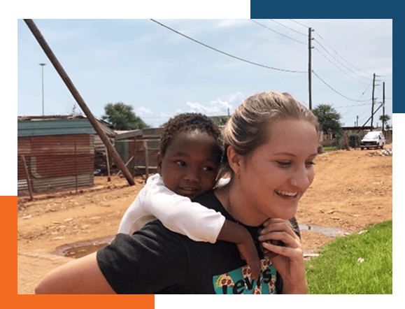 A worldwide medical insurance member giving a child a piggy-back ride across the street