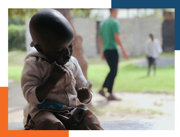 Small-African-child-with-others-playing-with-others-in-background Small African child in forground as others play in the background.